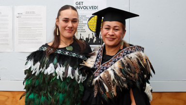 two women wearing a graduation cap and gown