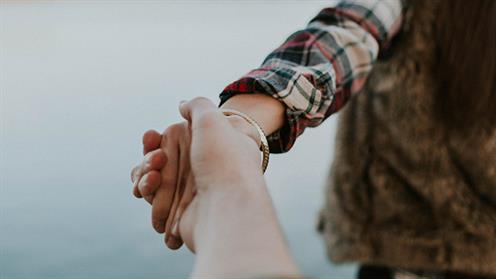 A close up photograph of two people holding hands A close up photograph of two people holding hands
