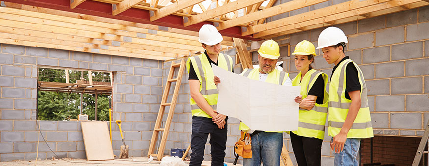 Construction students reviewing building plans with instructor